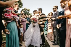 Wyjście pary młodej z kościoła wśród gości sypiących ryż